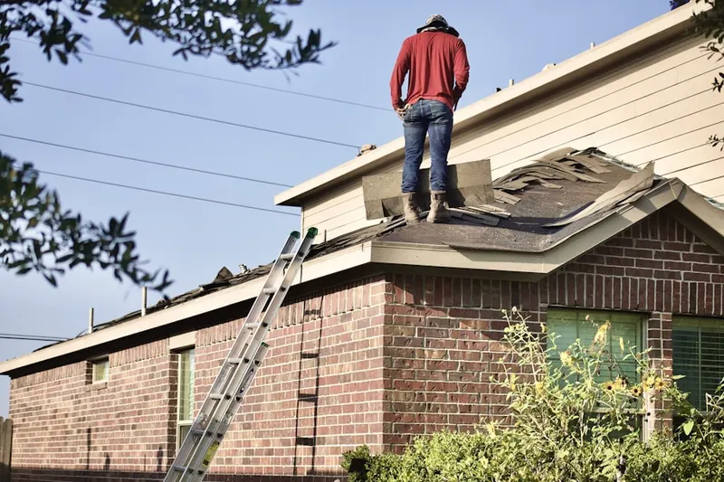 Professional roofer working on a residential roof in Clinton Township